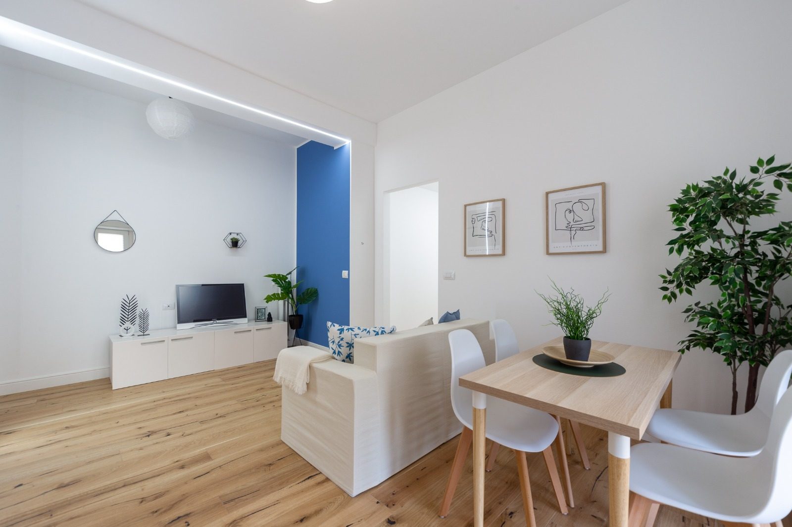 Soggiorno finito con illuminazione lineare a LED e pavimento in rovere