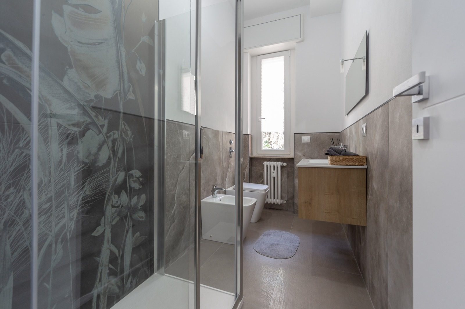 Bagno con box doccia in cristallo e mobile lavabo sospeso