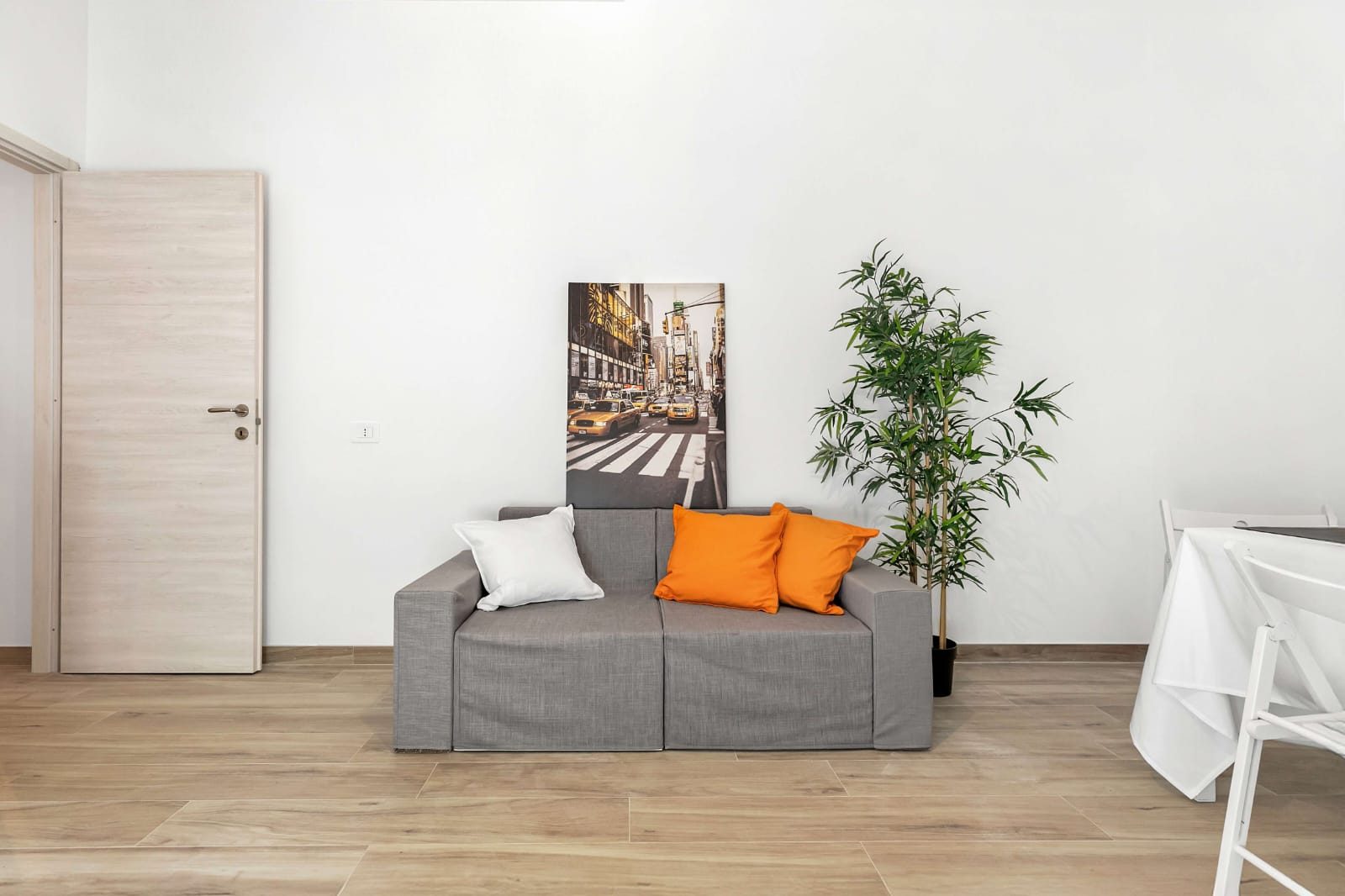 Zona giorno con porta nuova e pavimento in gres effetto legno chiaro
