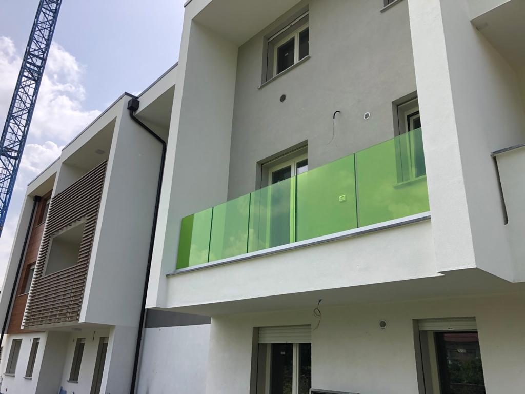 Balconi con parapetti in vetro e frangisole in legno di un edificio nuovo