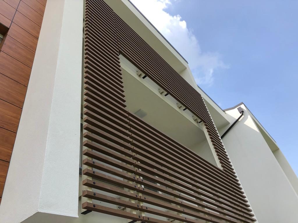 Dettaglio dei frangisole in listelli di legno sulla loggia