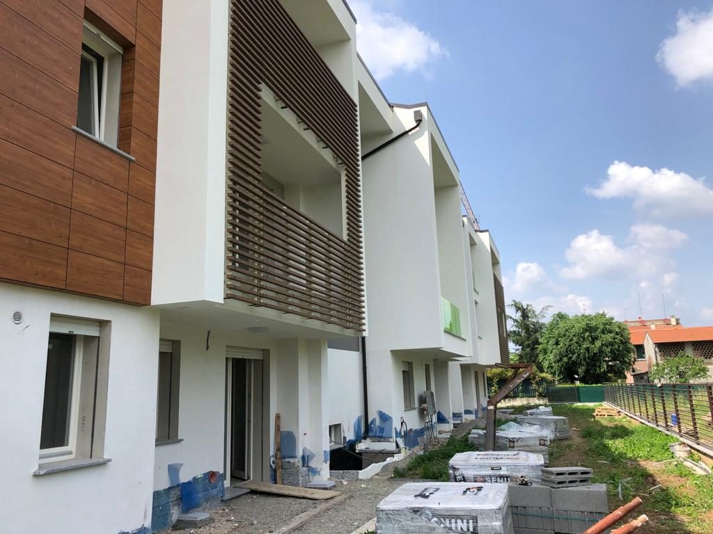 Fronte laterale di case a schiera nuove con rivestimento effetto legno e materiali su pallet