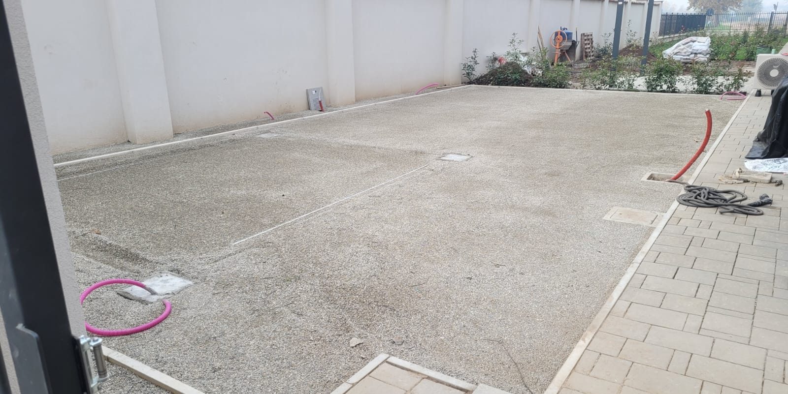 Il cortile durante i lavori, con sottofondo e sottoservizi in posa