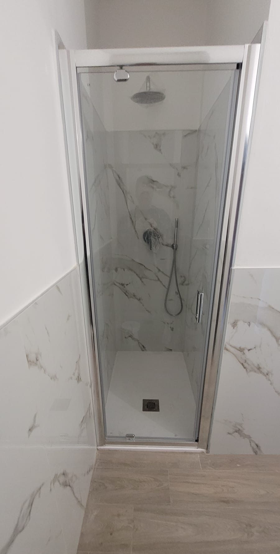 Doccia walk-in con piatto a filo pavimento e lastre in gres effetto marmo