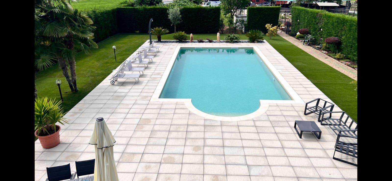 Vista dall'alto della piscina finita con il giardino e il camminamento