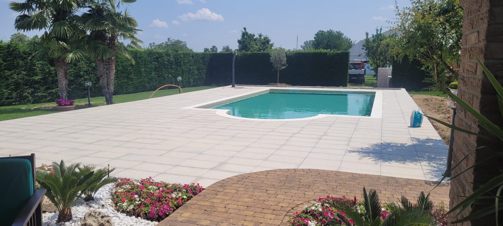 Piscina interrata completata, con pavimentazione perimetrale e giardino